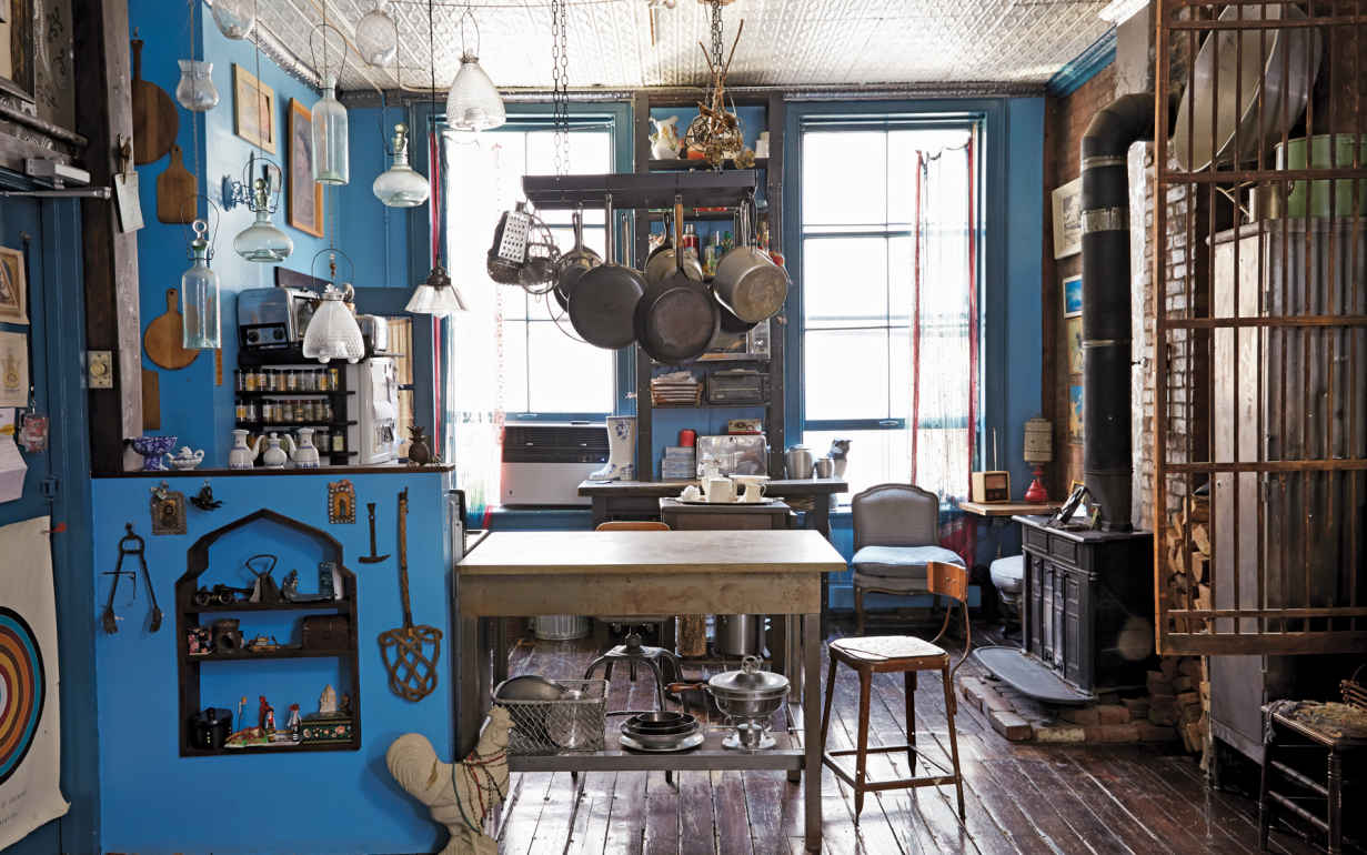 HANG IT HIGHER. Ceilings can provide very effective storage solutions. Beyond the hanging glass flycatchers, the commercial pot rack forms a central hub, keeping every pan within arm’s reach.